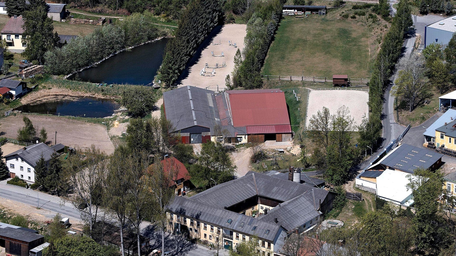 Luftbild der Reitanlage mit Stallungen, Reitplätzen und Teichen